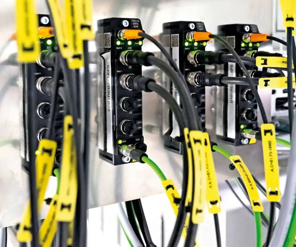 Turck’s TBEN RFID interfaces with IP67 protection are screwed onto a metal panel in a cabinet-free installation in the warehouse.