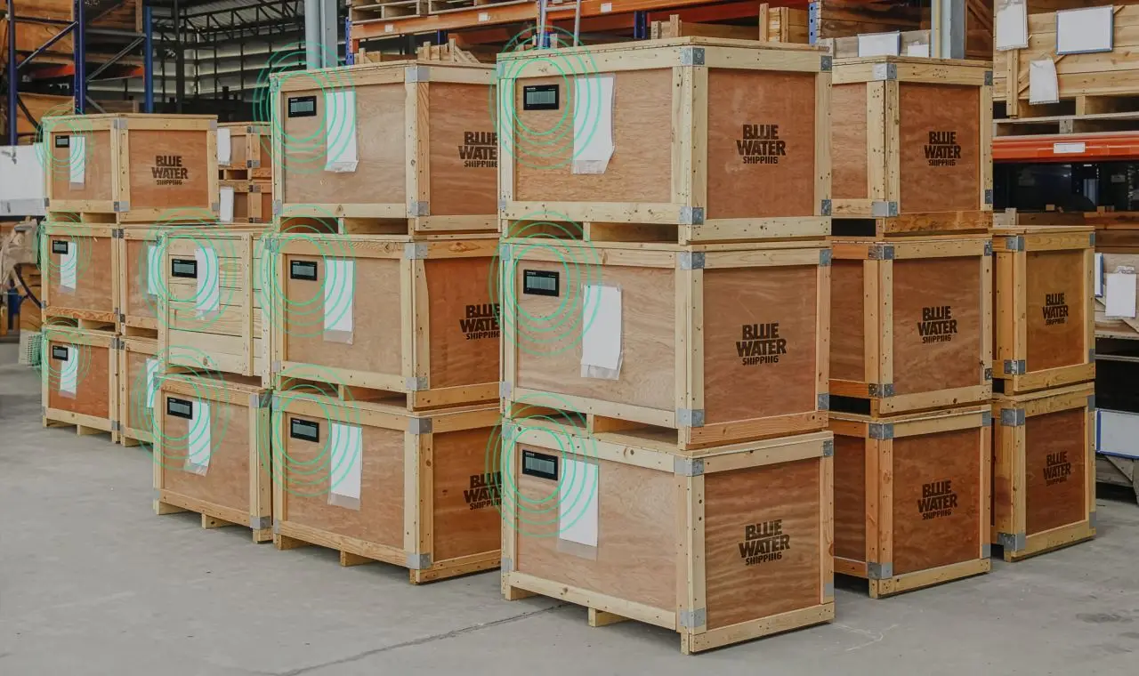 Stacked shipping crates in a warehouse equipped with smart tracking labels, enabling maintenance-free asset visibility in intralogistics.