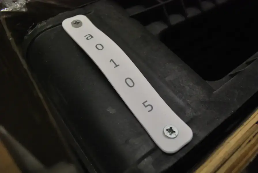 Une étiquette RFID en silicone plate, fixée sur un conteneur industriel, qui permet un marquage flexible et durable en extérieur.