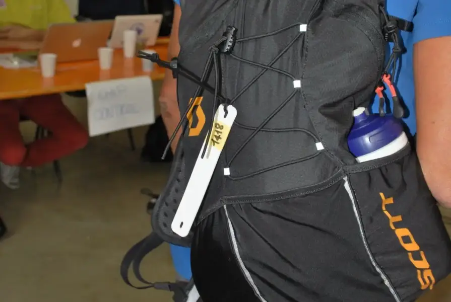 Une étiquette RFID en silicone de forme ovale, fixée à un sac à dos à l'aide de serre-câbles, qui permet une identification flexible et durable d'objets dans le cadre d'applications mobiles.